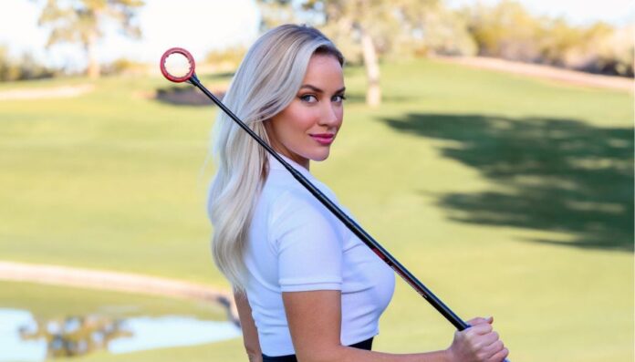 Paige Spiranac wearing a white top and holding a golf stick